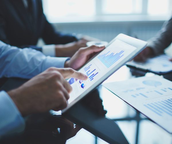 Image of businessperson pointing at document in touchpad at meeting